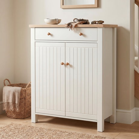 [White] Linra White 4 Tier Shoe Storage Cabinet front-facing with both beadboard doors closed alongside woven basket with throw blanket and staircase in background
