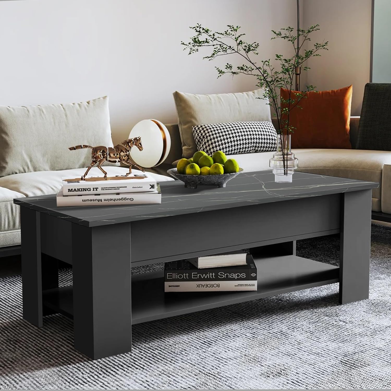 Modern marble top coffee table with a gray base, decorative sculpture, and books in a living room