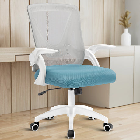 A grey and Tiffany blue mesh chair is placed in a home office with a working desk in the background for support.