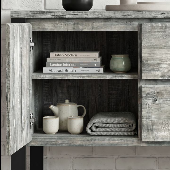 [Grey] Millwright sideboard open cabinet view with shelves, books, ceramics, and folded table cloth inside