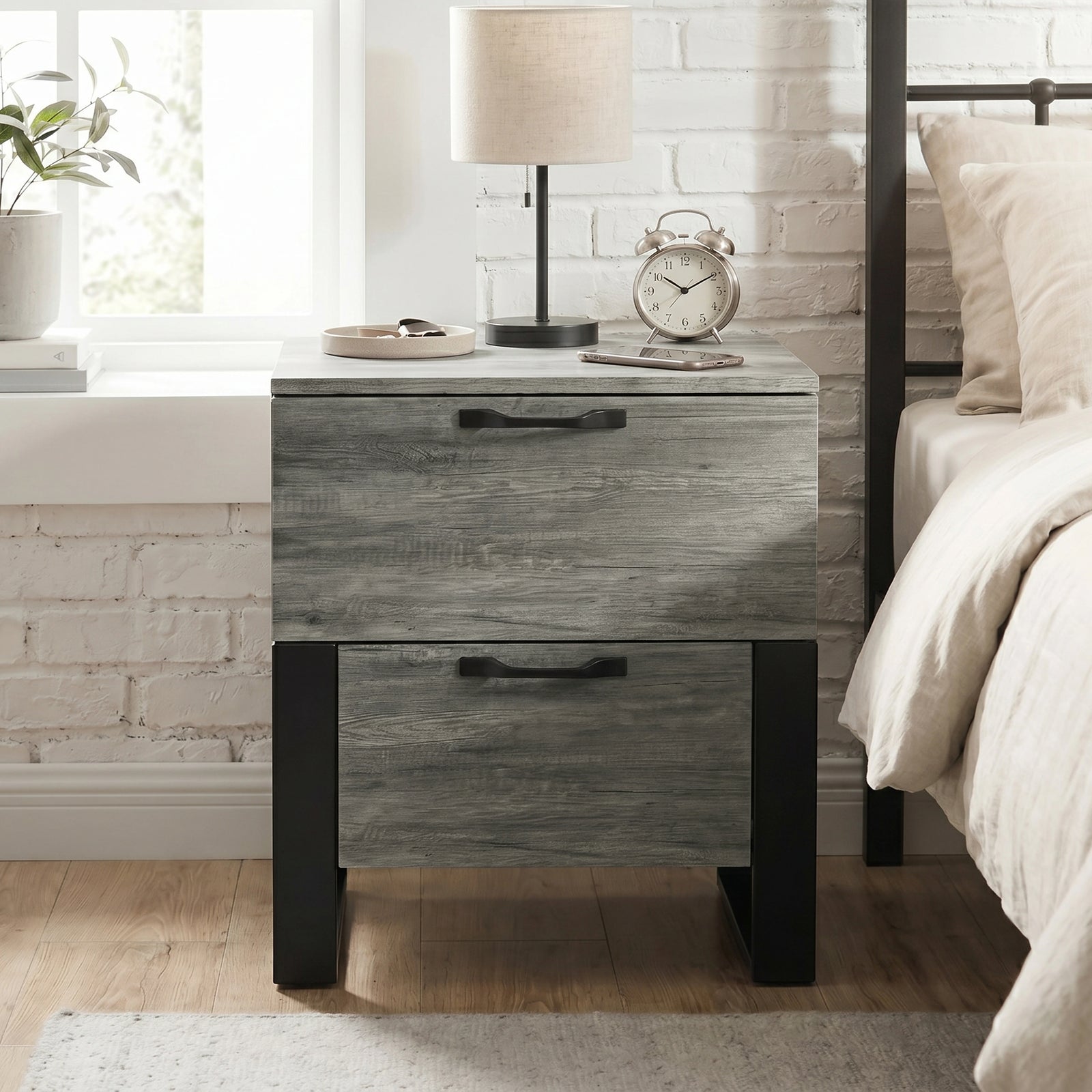 [Wooden Grey] Millwright industrial 2 drawer bedside table with black legs shown beside a bed
