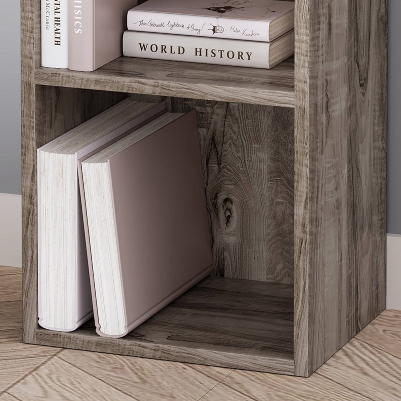 Close-up of rustic Blisswood bookcase bottom shelf with large books, showcasing wood grain texture.