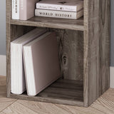 Close-up of rustic Blisswood bookcase bottom shelf with large books, showcasing wood grain texture.