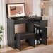 Black makeup vanity table with illuminated mirror in a room setting.
