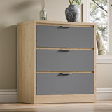 Three-drawer chest of drawers in two tone finish, placed against a wall near a window in a natural light setting