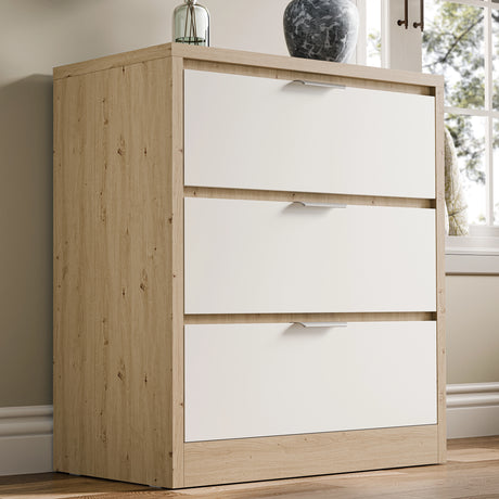 Skova chest of drawers, a three-drawer unit in white and wooden finish, placed against a wall in natural light near a window