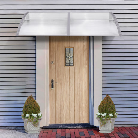 Modern front door canopy UK with clear polycarbonate sheet and gray aluminum brackets.