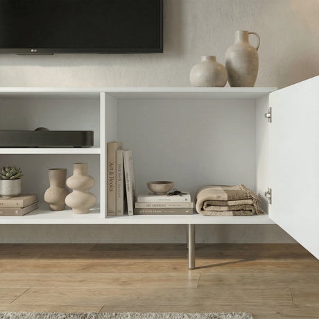 Interior view of a white modern TV unit showing open storage shelves and fluted doors for organized media accessories.