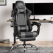 Xstriker Gaming Chair With Footrest in black and grey, featuring ergonomic lumbar support and headrest, placed in a modern home office setup.