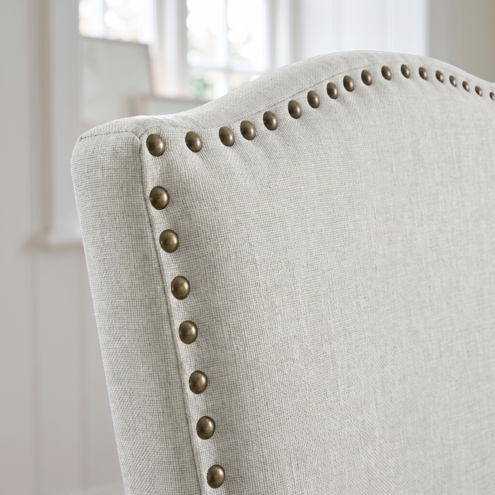 [Beige | Set of 2] Close-up of curved high back with fabric upholstery and bronze nailhead trim