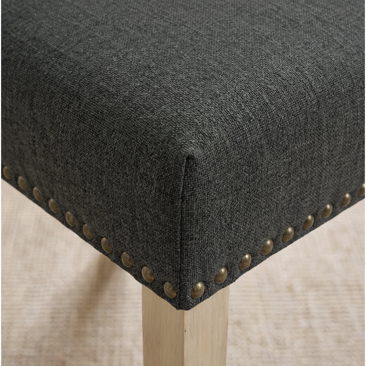 [Dark Grey | Set of 2] Close-up of fabric seat, bronze nailhead trim and light wooden leg on the dining chair