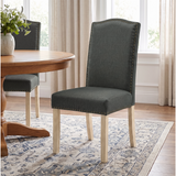 [Dark Grey | Set of 2] Nailhead dining chair beside a round wooden table in a bright dining room