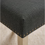 [Dark Grey | Set of 4] Close-up of fabric seat, bronze nailhead trim and light wooden leg on the dining chair