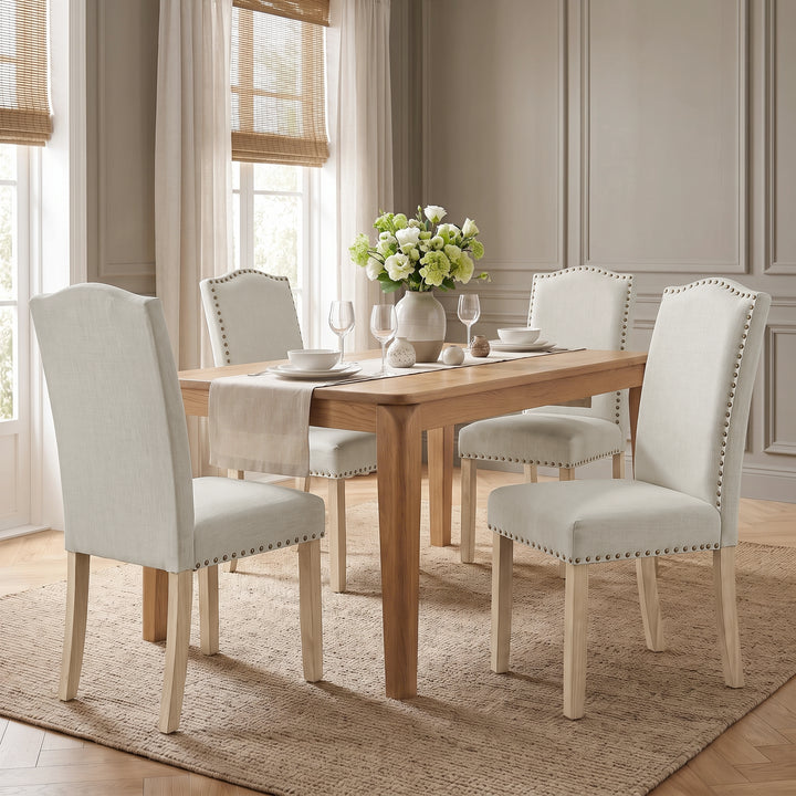 [Beige | Set of 4] Nailhead Dining Chairs set of 4 in beige fabric styled around a wooden dining table.