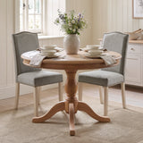 [Light Grey | Set of 2] Two nailhead dining chairs shown around a round wooden dining table in a dining room