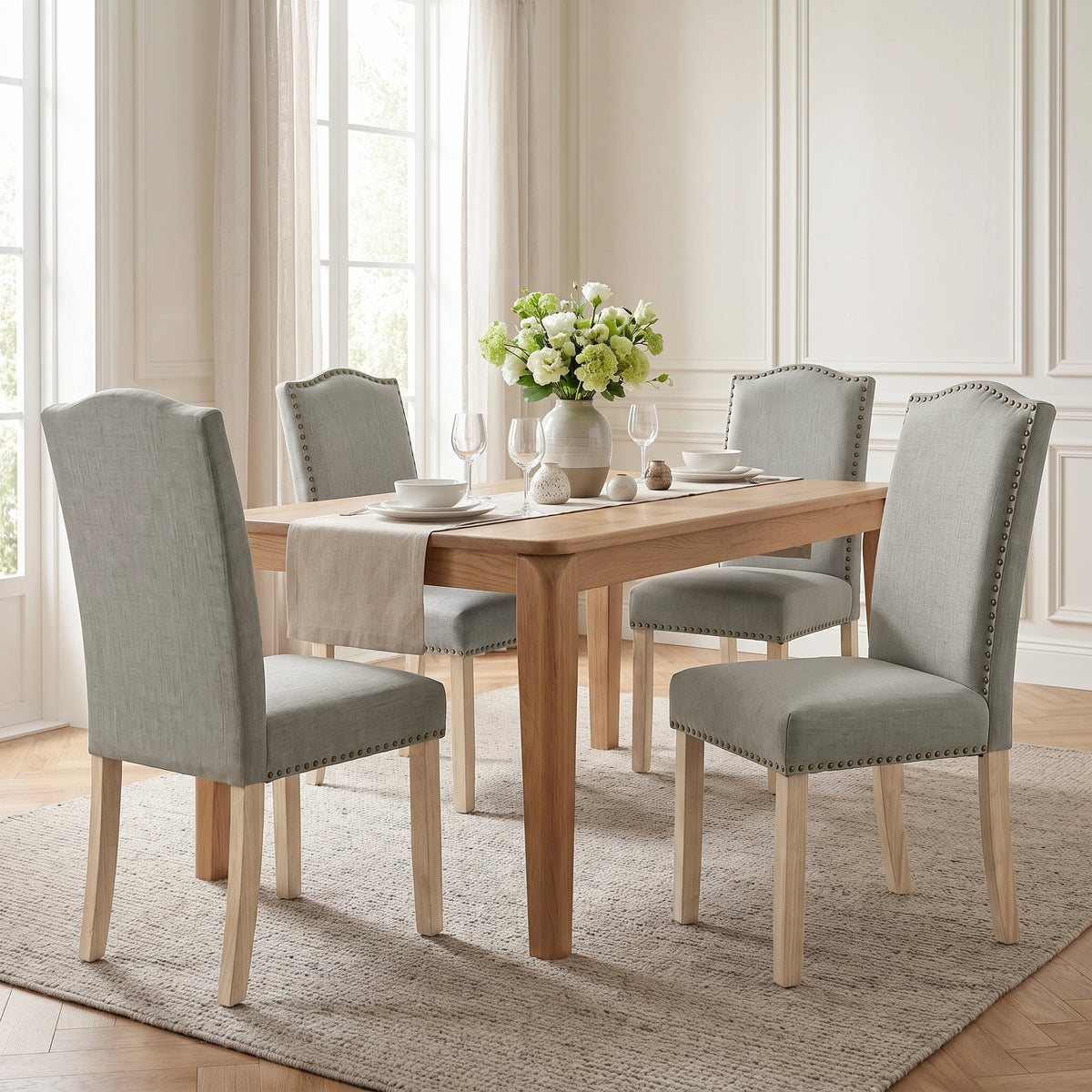 [Light Grey | Set of 4] A 4-piece dining set featuring a rectangular light oak wood table and four upholstered dining chairs in a light gray fabric with nailhead trim