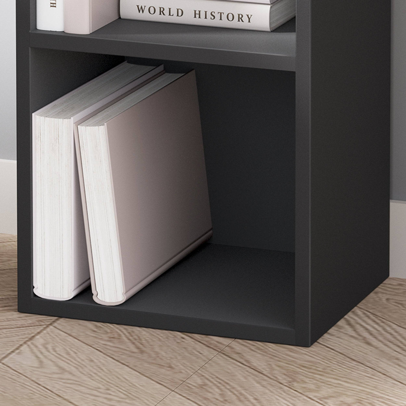 Lower shelf of black Blisswood bookcase with large books, showcasing sturdy and functional design.