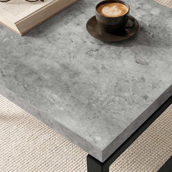 [Concrete] Nestline nesting coffee table tabletop closeup of detail with a dark cup on grey stone texture and softly bevelled
