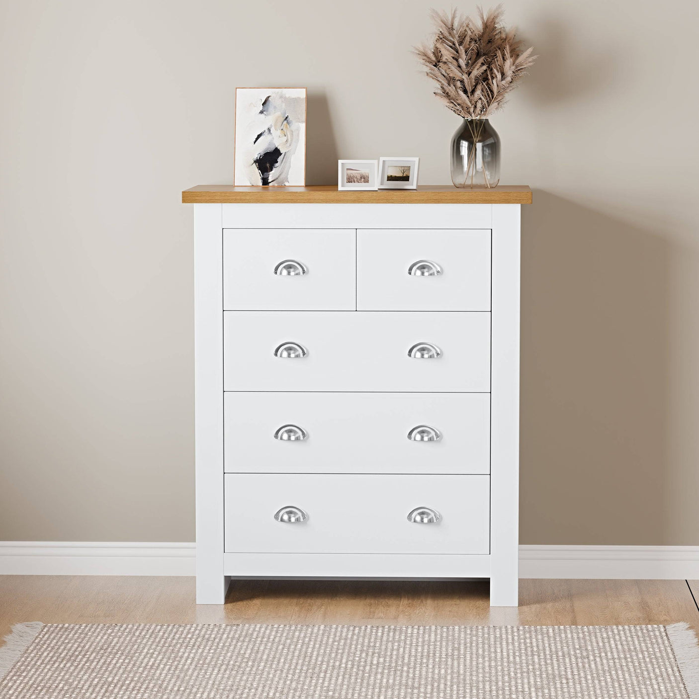 Oak bedroom chest of drawers with handles and top surface for flower pot display.