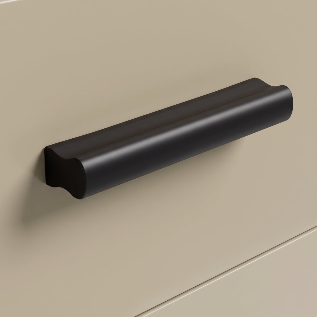 [Oak+Cashmere] Macro close-up view of the smooth black matt drawer pull handle mounted on a beige matt drawer front panel
