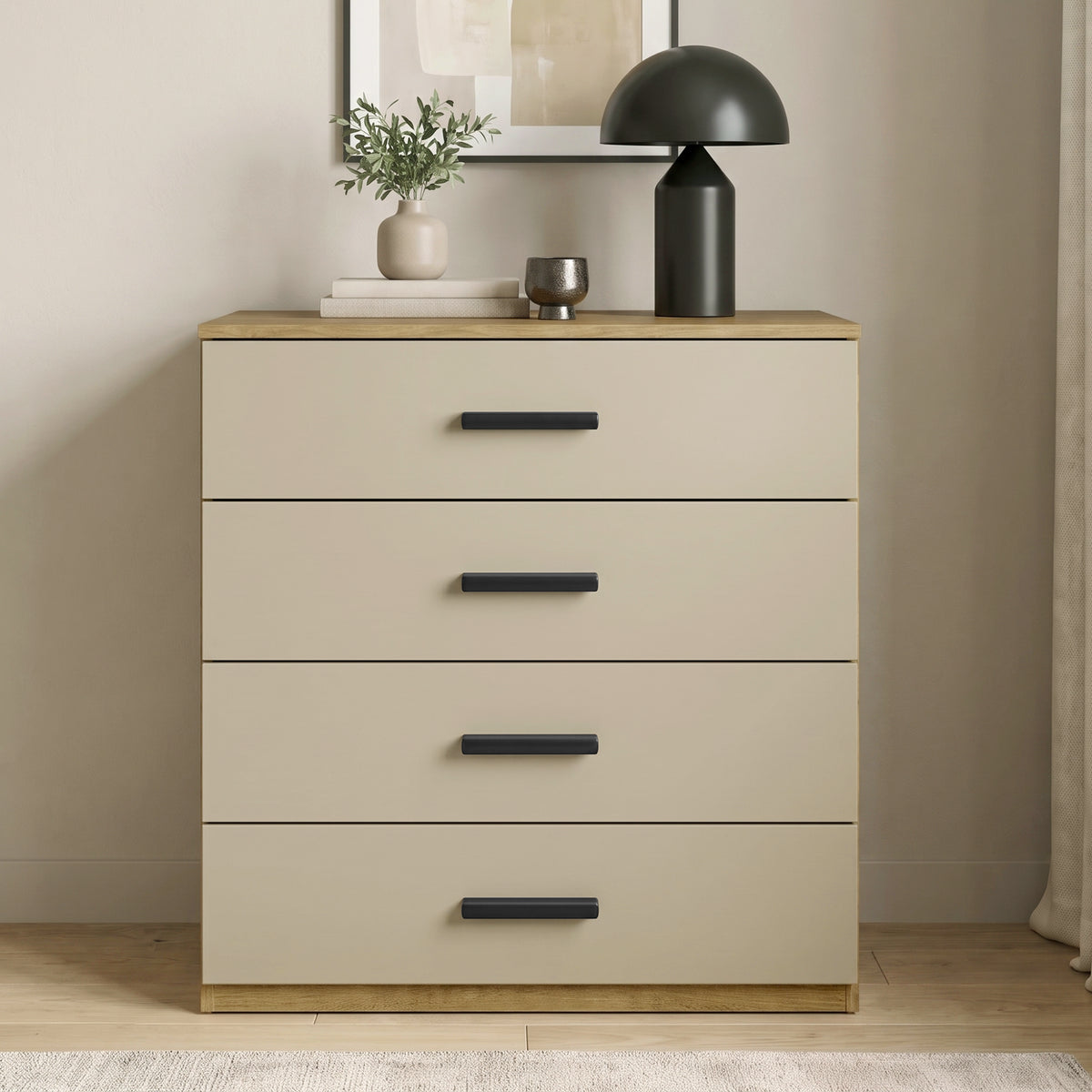 [Oak+Cashmere] Front view of a modern oak frame and beige 4-drawer chest with black handles styled against a neutral room wall