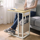 [Oak] C-shaped side table used for laptop work by sofa with charging station plugged in wall socket and storage pouch