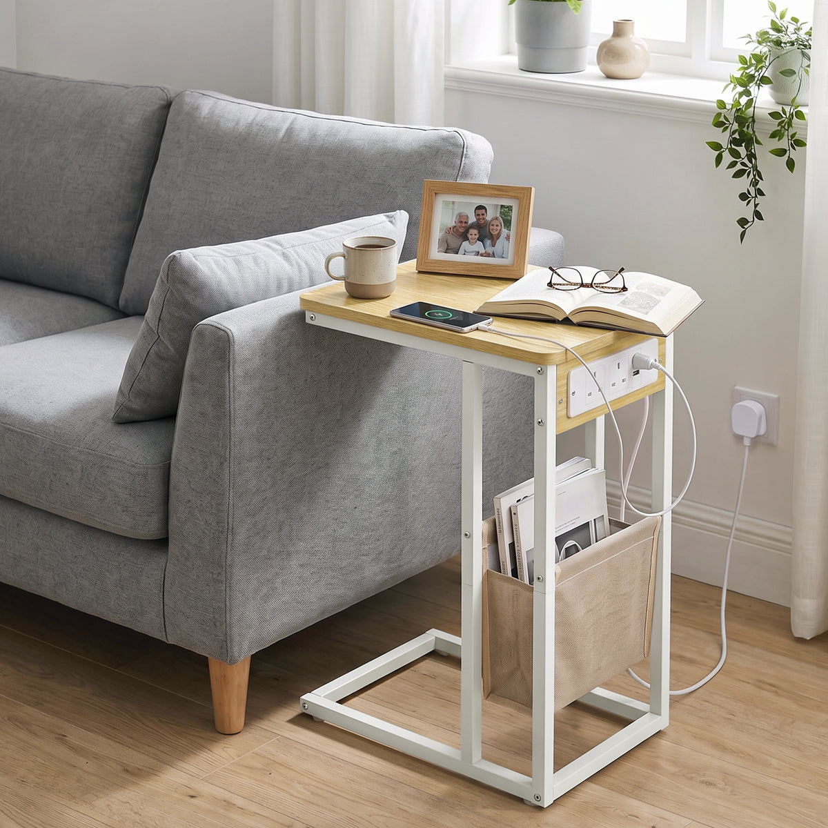 [Oak] sofa side table side view with oak-effect top, socket panel, tea, power cable and storage pouch