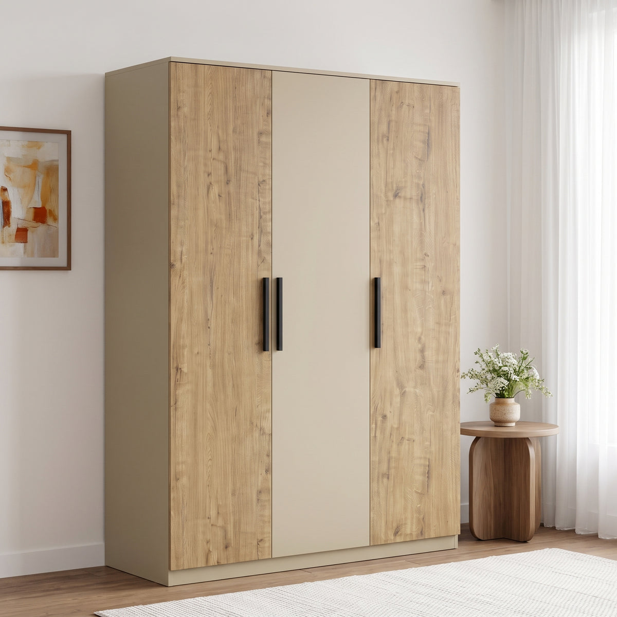 [Oak+Cashmere] Angled room view of a closed three door wardrobe with mixed panels, black handles, and side table