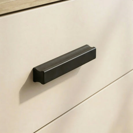 [Oak+Cashmere] Close up of oak and cashmere drawer front with matte black handle and smooth painted surface