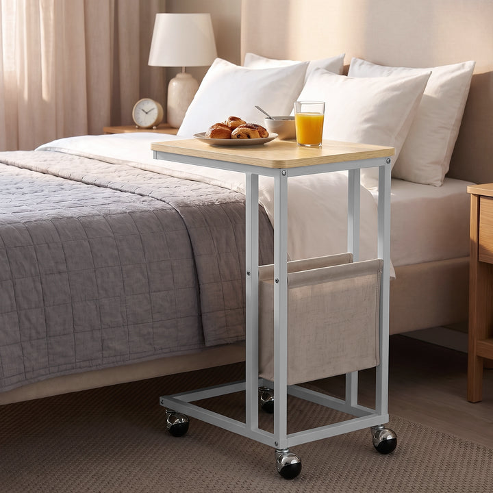[Oak] side table beside bed with oak-effect top, side pouch storage, snacks and rolling caster wheels