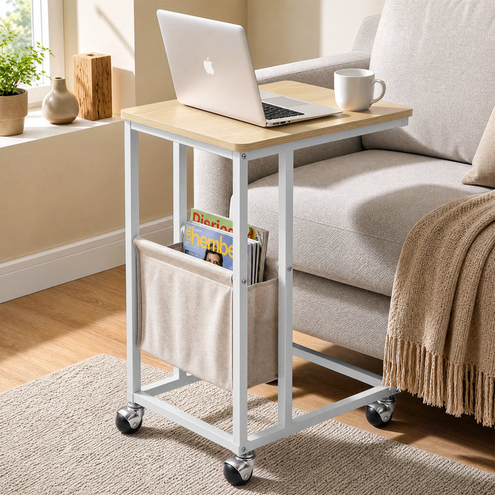 [Oak] C-shaped side table by sofa with oak-effect top, white frame, pouch, laptop and caster wheels