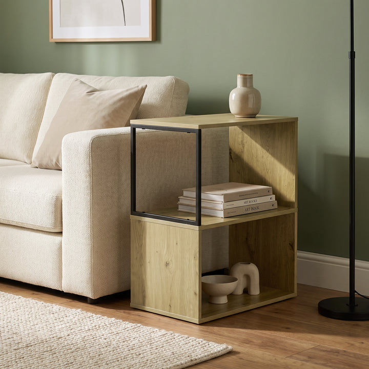 [Oak] This narrow side table stands beside a sofa with books and decor arranged on its open shelves.