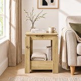[Oak] Front view of the square side table beside a sofa, with books and a folded throw stored below