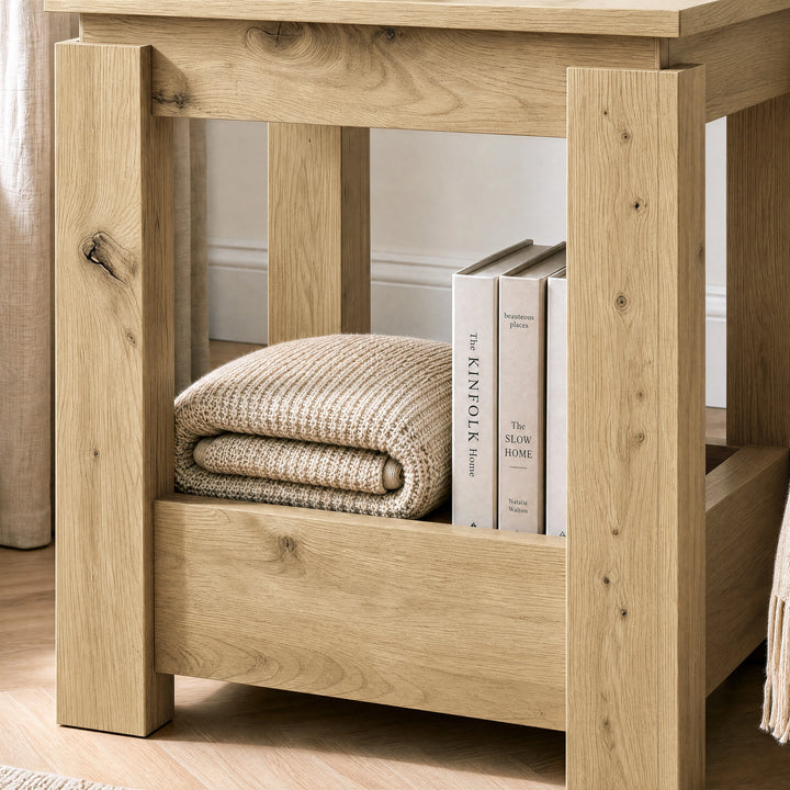 [Oak] Close-up of the square side table's open lower storage holding books and a folded throw