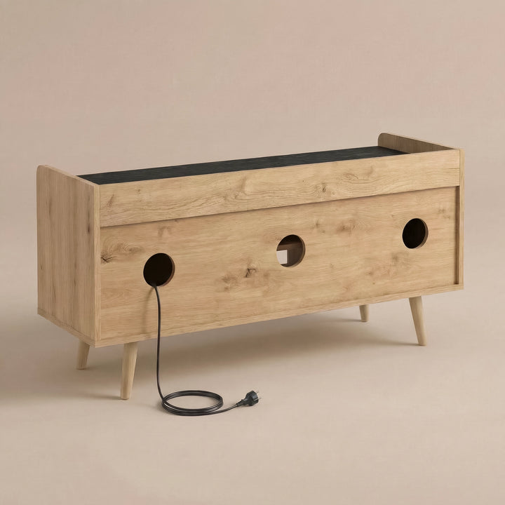 [Oak] modern tv unit storage cabinet with a light oak finish, featuring three circular cutouts on the back, a black top surface, and tapered legs, shown on a warm beige background.