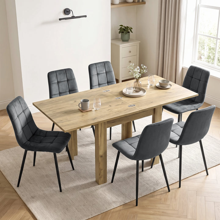[Oak] Extended flip-top dining table with six grey chairs, flower vase, four glasses, mug, bowl and plate