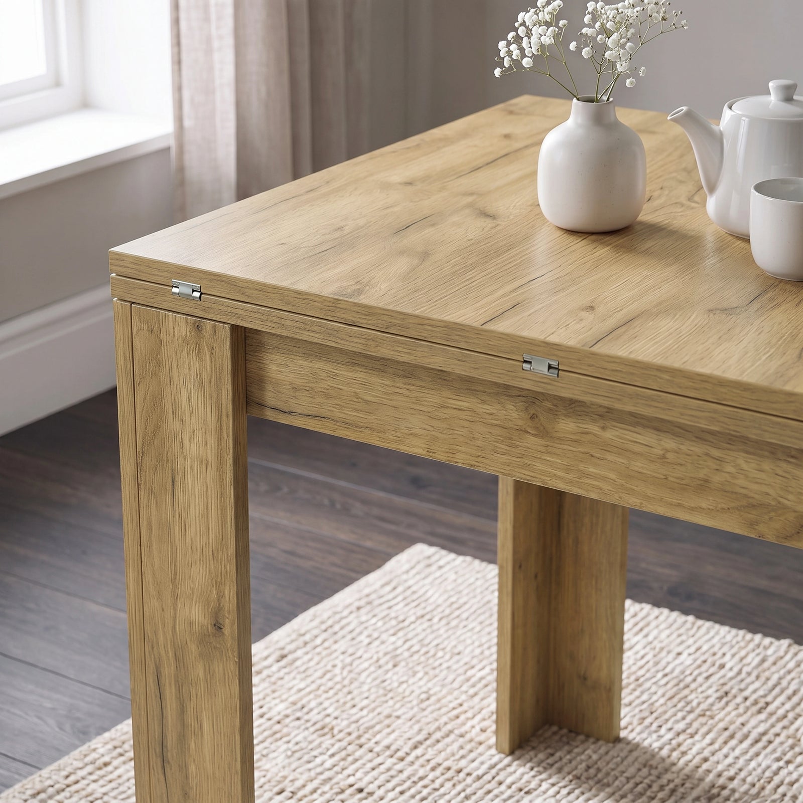 [Oak] Close-up of the folded wood-grain square tabletop, steel hinges, wide legs, white flower vase, teapot and cup