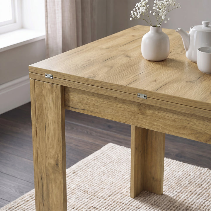 [Oak] Close-up of the folded wood-grain square tabletop, steel hinges, wide legs, white flower vase, teapot and cup