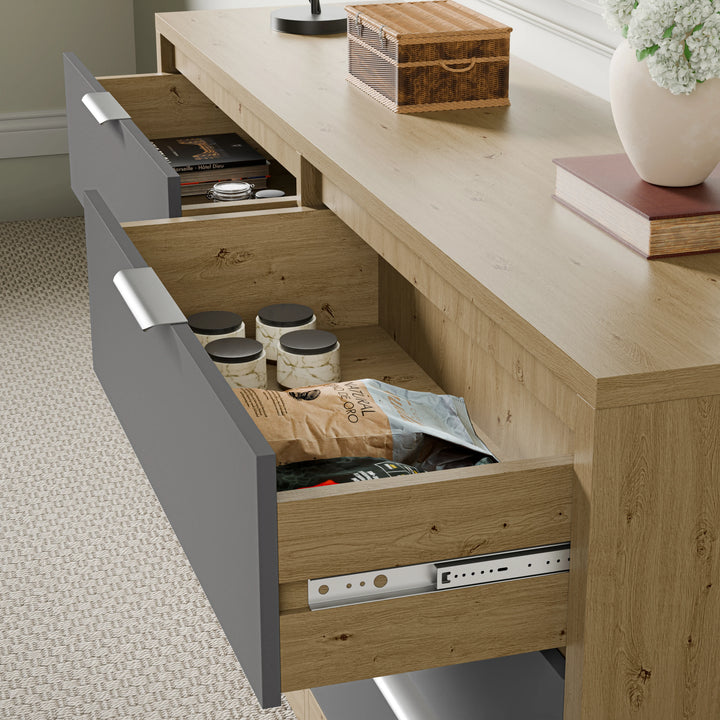 Wooden grey chest of drawers with two drawers partially open with smooth runner, showing small jars and items