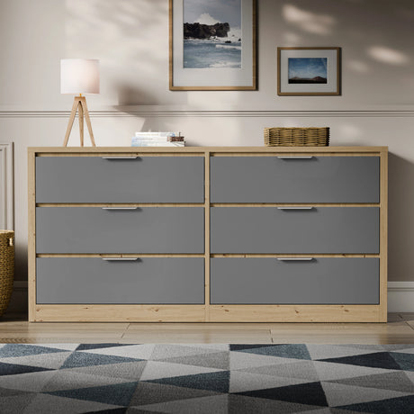 Two-tone finish wide chest of drawers placed in a bright room with a patterned rug and lamp