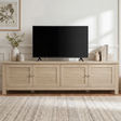 [Oak] Oskara TV unit 180cm main lifestyle shot with large TV on top, botanical plant, neutral room