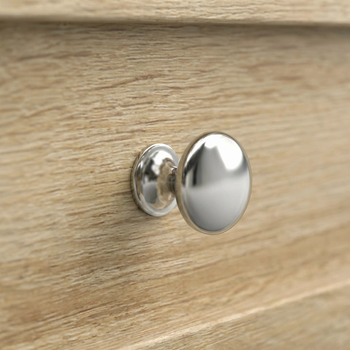 [Oak] Oskara TV Unit with Storage close-up detail of a round polished chrome drawer knob set against the oak effect wood grain panel front