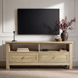 [Oak] Oskara TV unit front view in living room below wall-mounted TV styled with black candlestick, red berry vase, wooden bowl, and media player