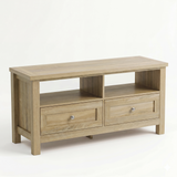 [Oak] Oskara TV unit isolated three-quarter view on white background showing oak top, two open shelf bays, and two shaker drawers with metallic knobs