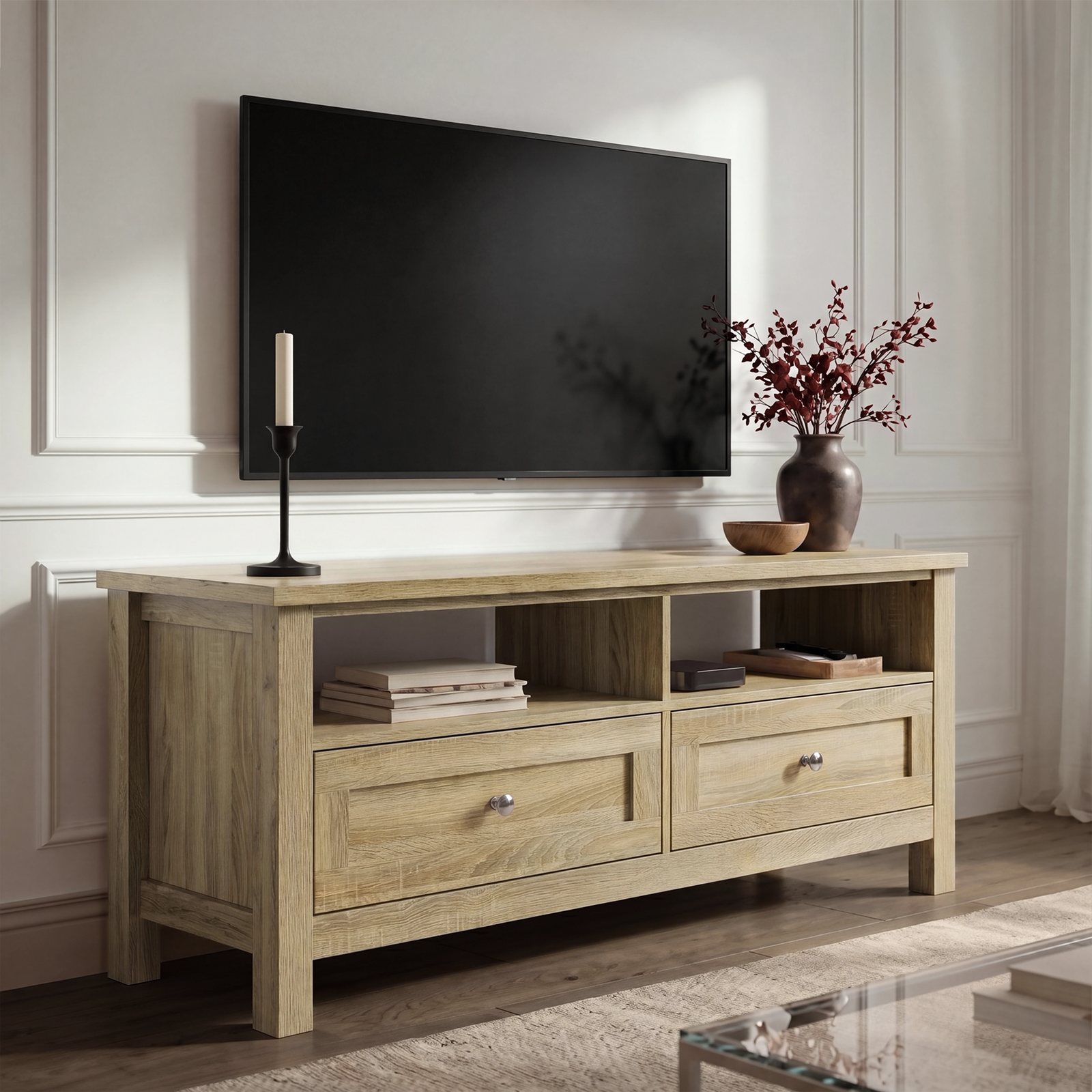[Oak] Oskara TV unit in a bright living room below a wall-mounted TV with open shelves holding books and media device beside red berry vase