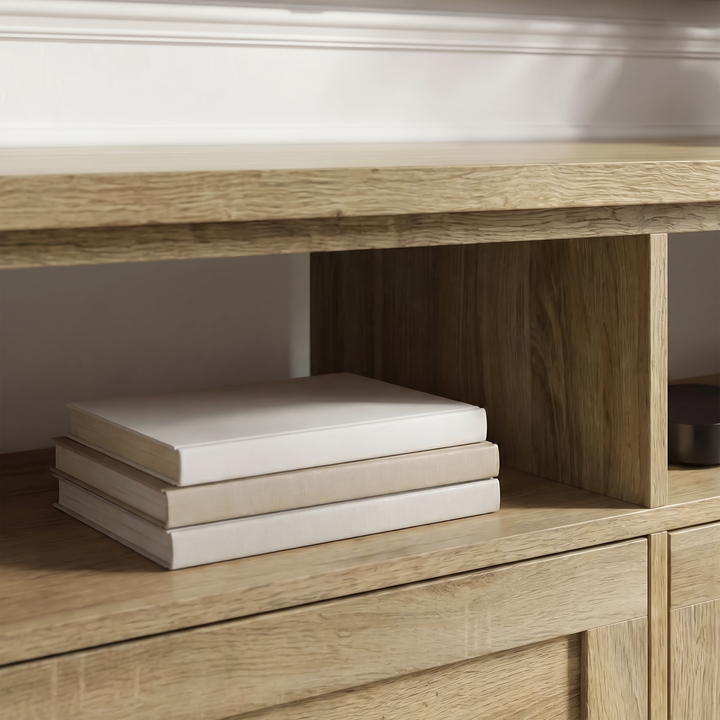 [Oak] Oskara TV unit close-up of open shelf cubby interior holding three stacked cream books on natural oak-grain shelf surface in living room