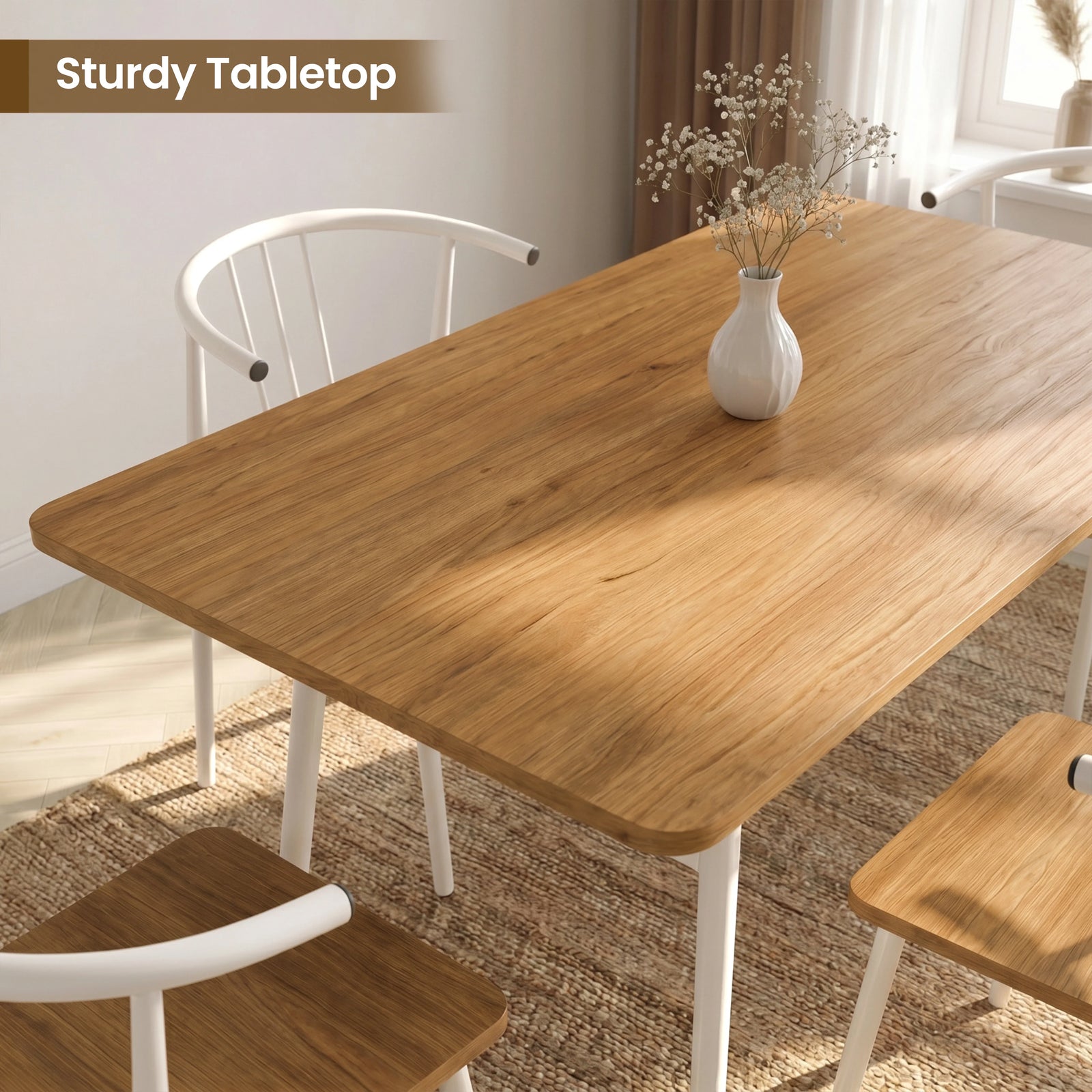 [Oak] Torvi dining table overhead close-up showing warm oak-effect tabletop surface with a small white vase and white metal arm chairs around it