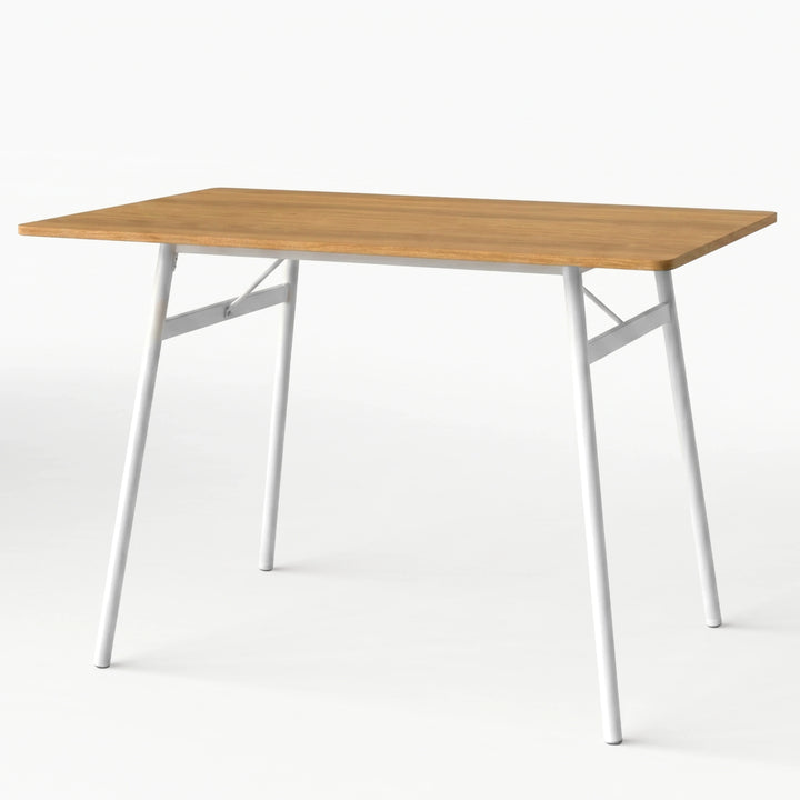 [Oak] Torvi dining table alone on white background showing warm oak-effect MDF top and white metal angled legs with cross-brace frame detail