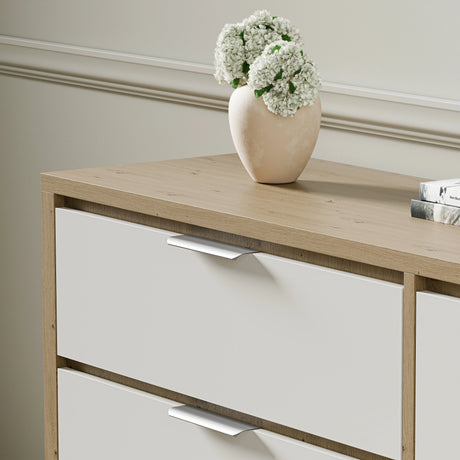 Skova Wide chest of drawers in a two-tone finish with metallic handles and a vase placed on top of it