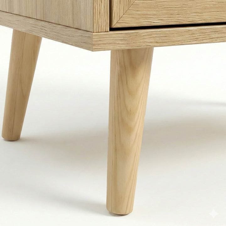 [Oak] Wovena rattan bedside foot detail with two front legs splayed outward on white floor